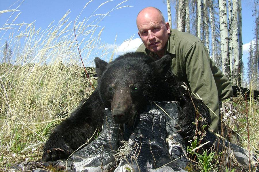 Hunter and a fresh black bear in the great outdoors